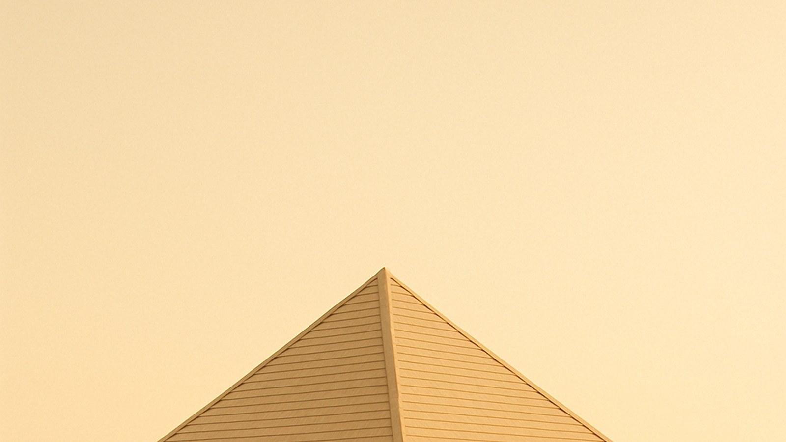 A simple wooden bathing pavilion with a pyramid roof on the empty sand of early Miami Beach